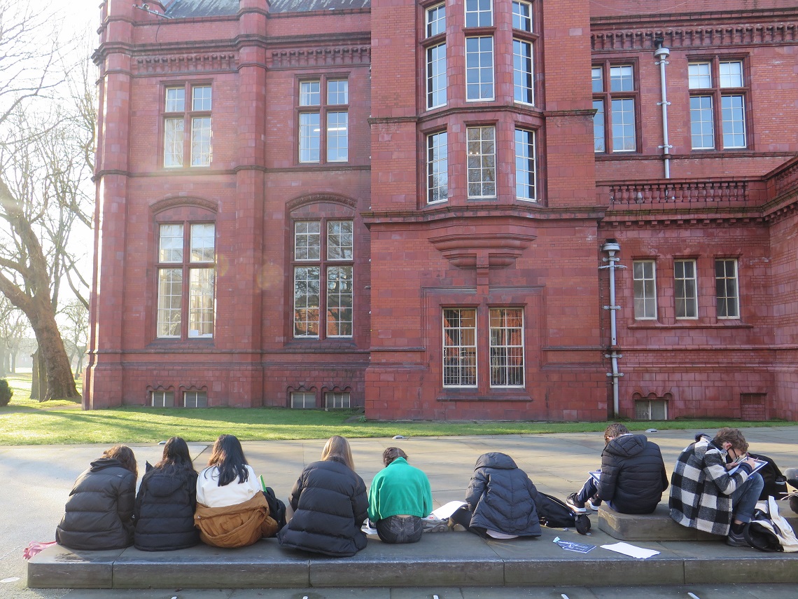 Pupils sit outside as they sketch the Whitworth Art Gallery