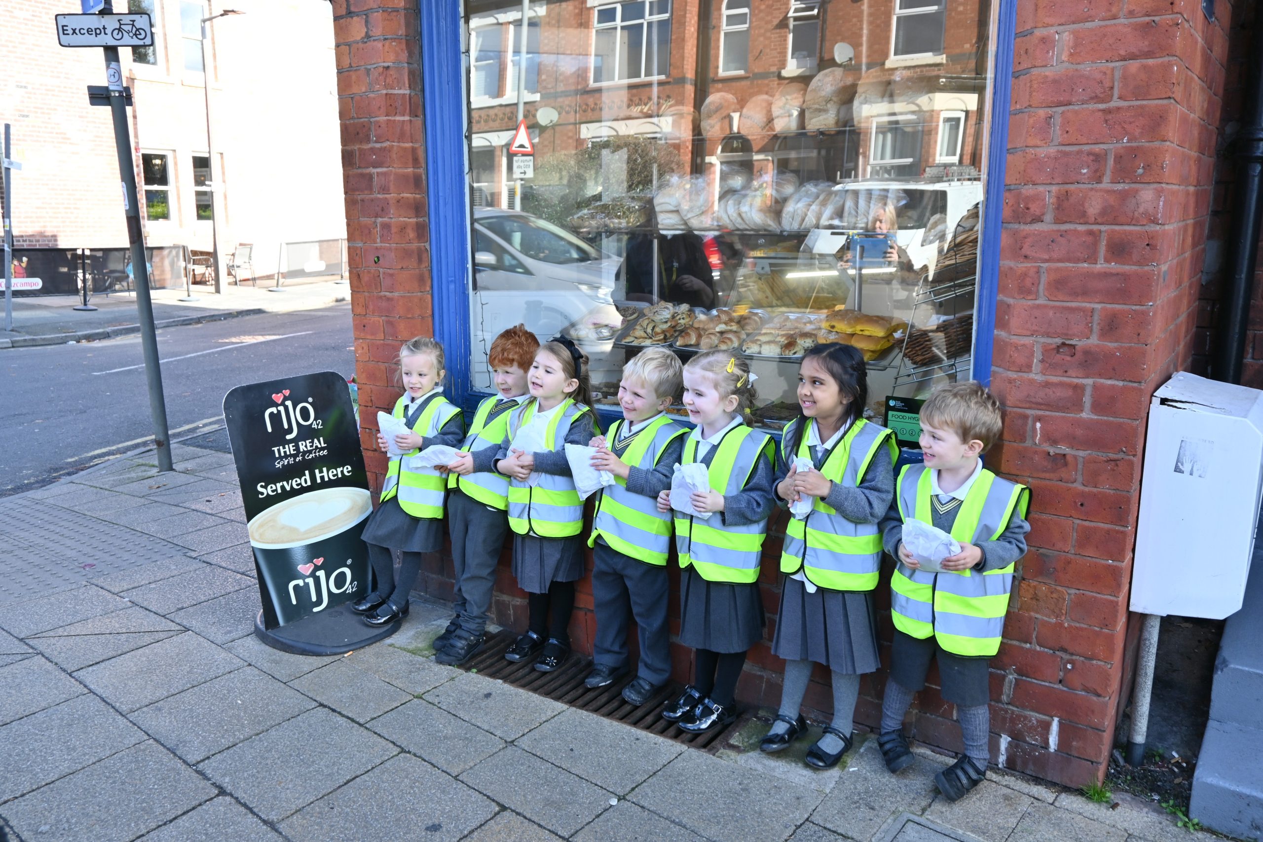 Nursery pupils proudly hold their rolls from the bakery