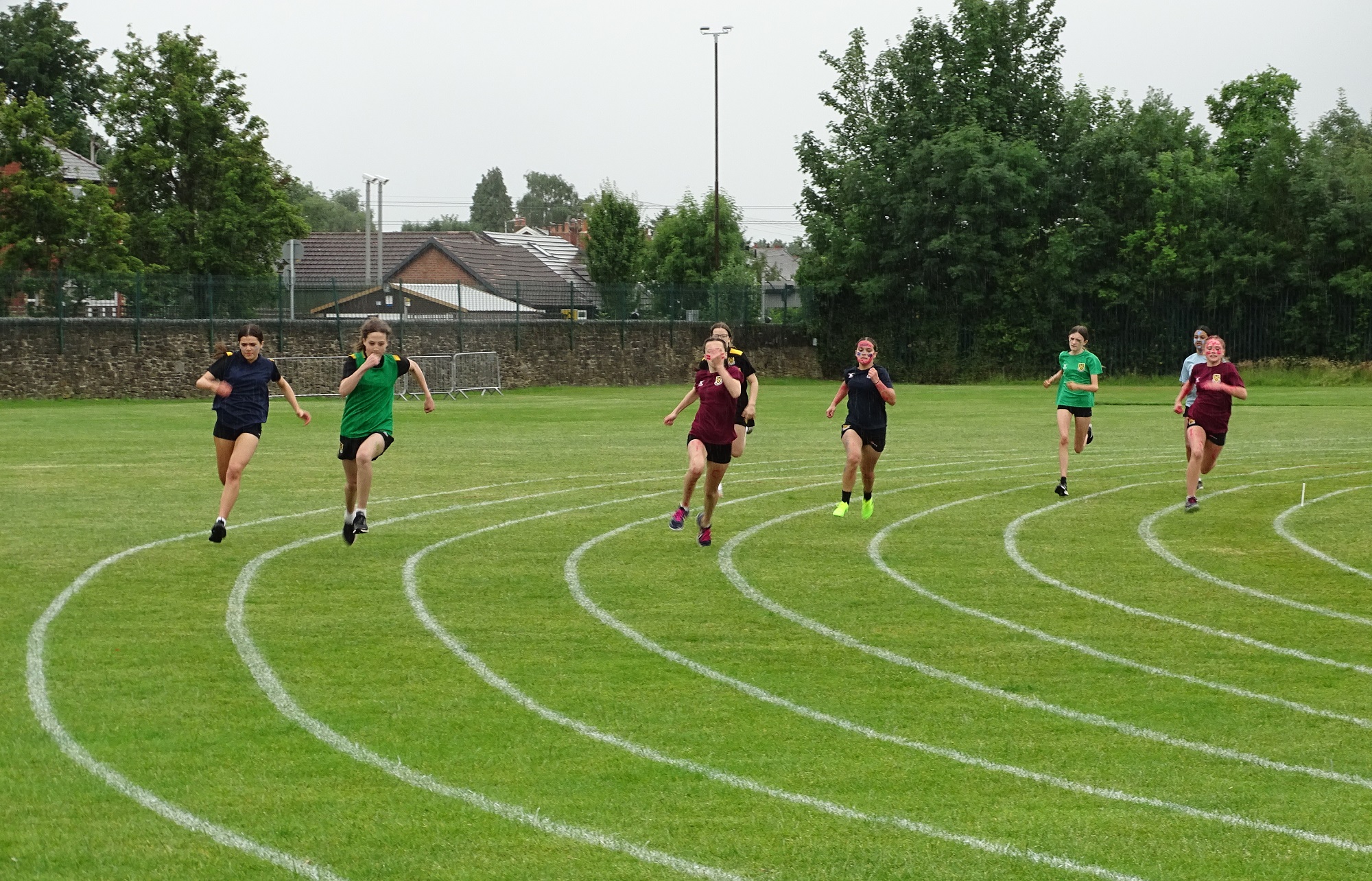 Girls race around a bend on the track during the 2023 First and Second Year Sports Day
