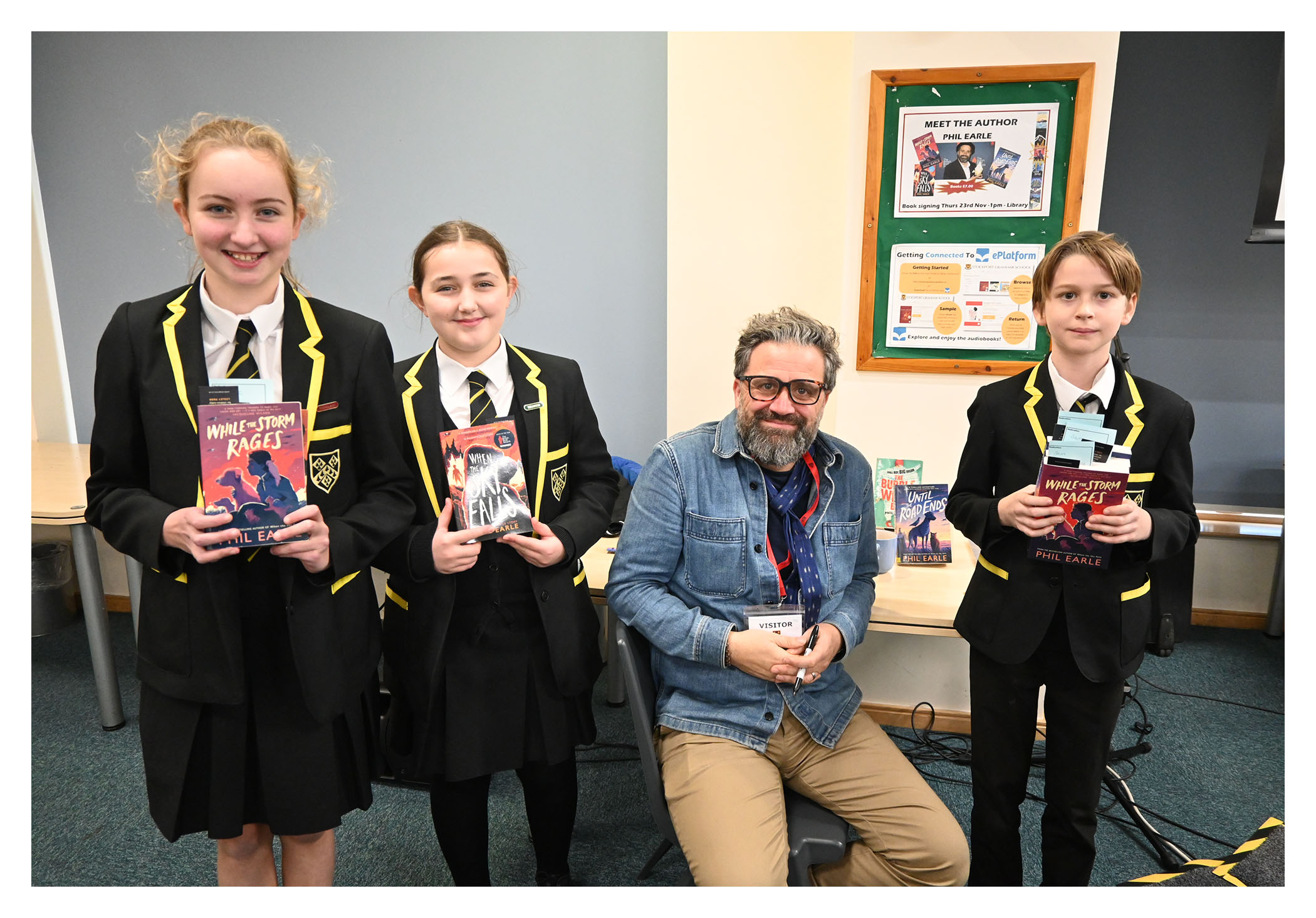 Pupils pose with books alongside author Phil Earle